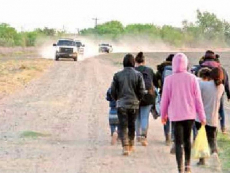 Vehículos de la Patrulla Fronteriza se acercan a familias de migrantes que solicitan asilo tras cruzar el Río Grande en Peñitas, Texas.